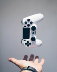 white PS4 controller falling into a hand